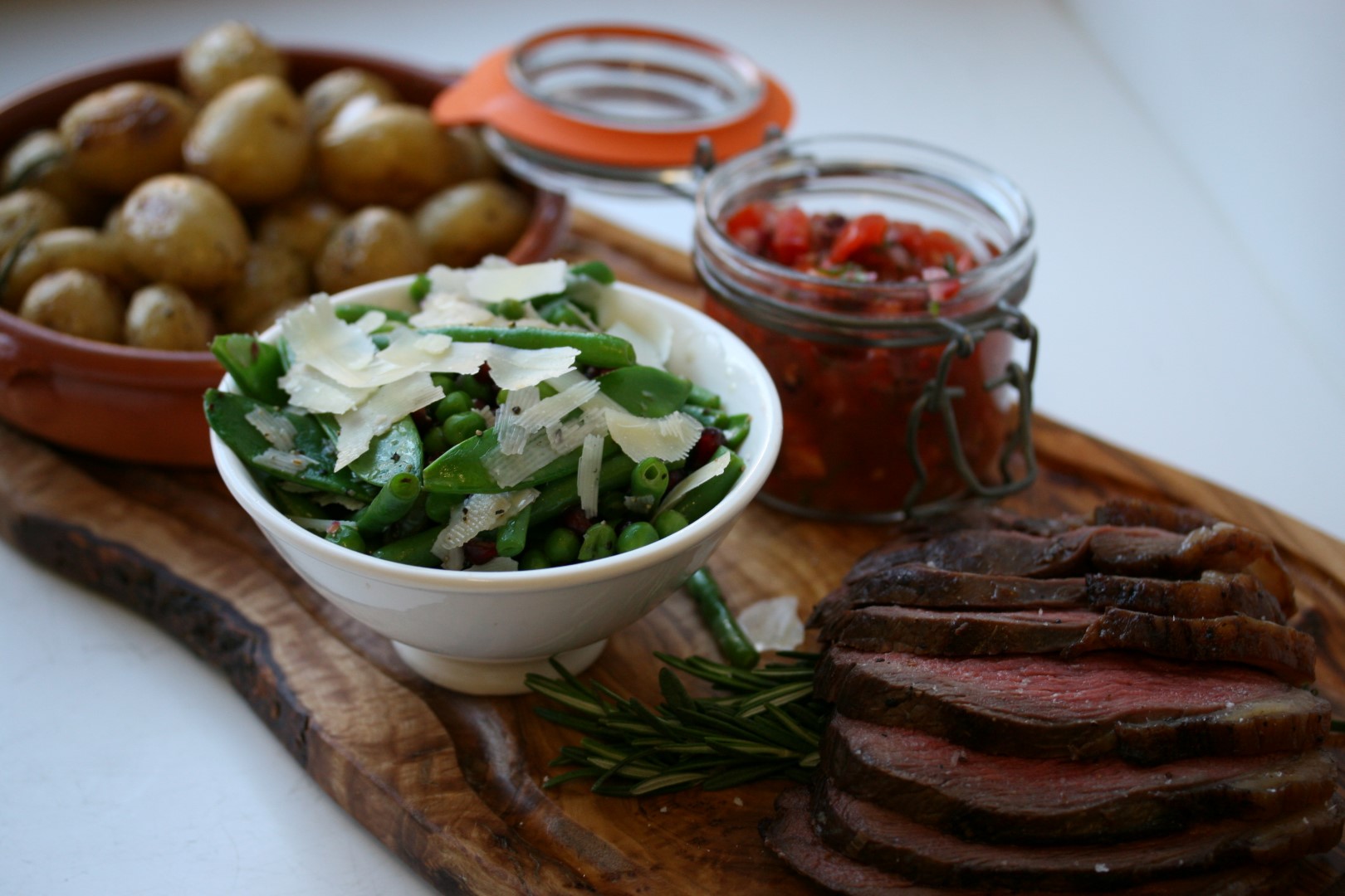 West Country rump of beef slowly cooked over charcoal with garlic and thyme roasted new potatoes, fine green beans, peas and pomegranate salad, tomato and chilli salsa (2)